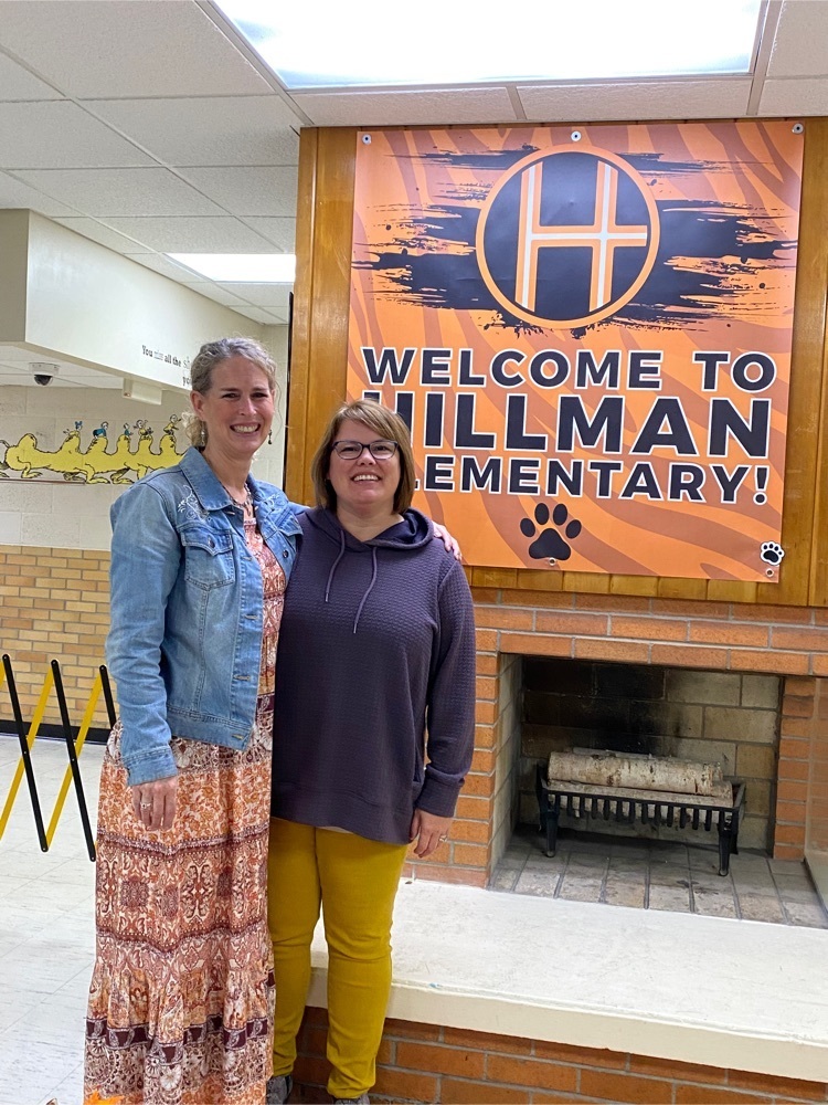 Principal and Teacher Consultant standing next to Hillman Logo 
